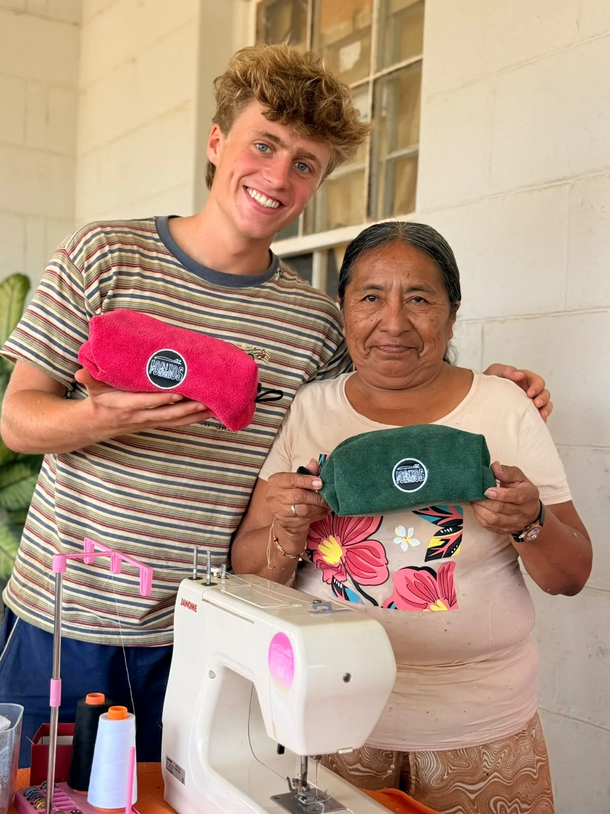 One of our grandmothers with a visitor, in front of her sewing machine